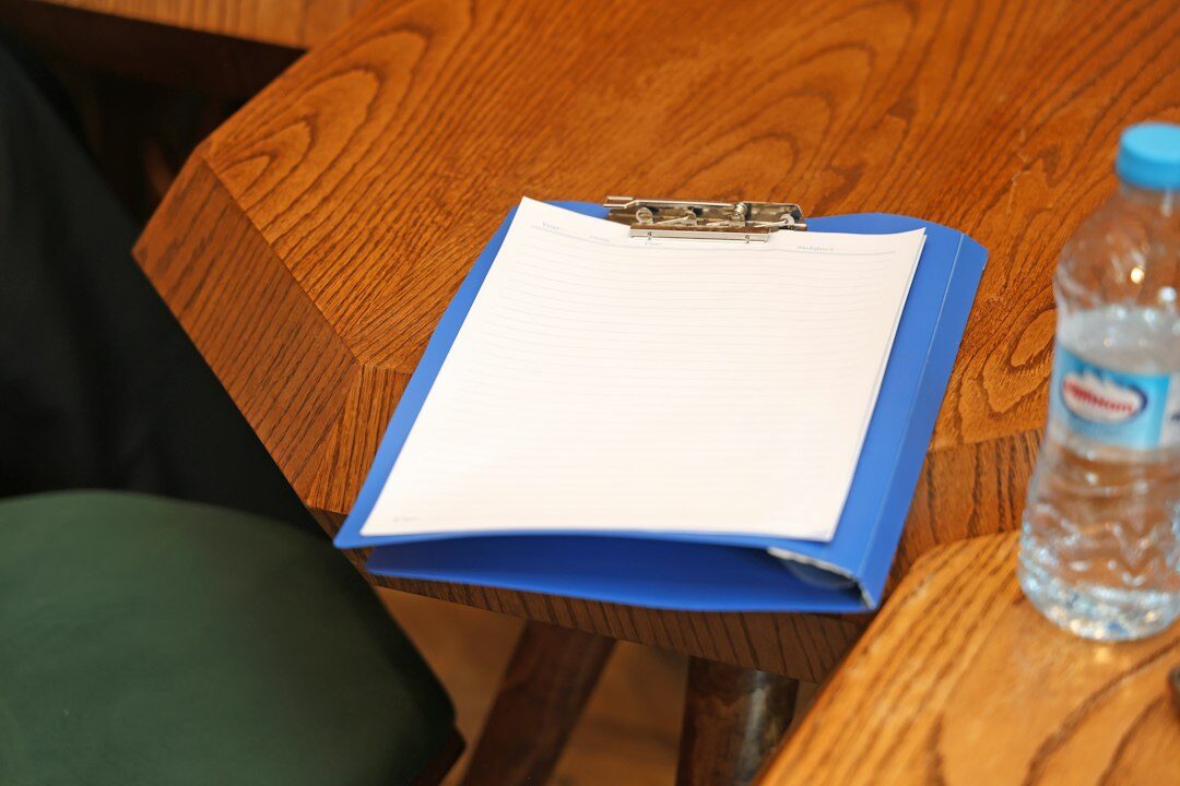 Researcher recording answers on a clipboard during a survey