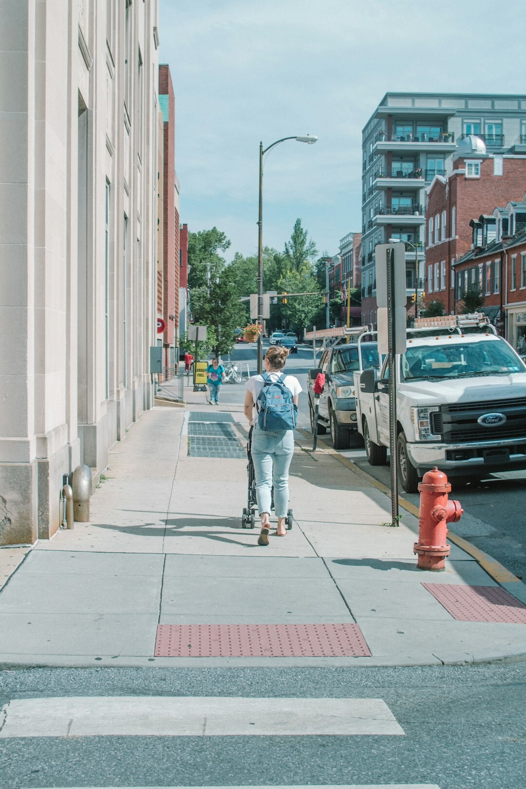 Researcher interviewing a pedestrian with a clipboard on a city street